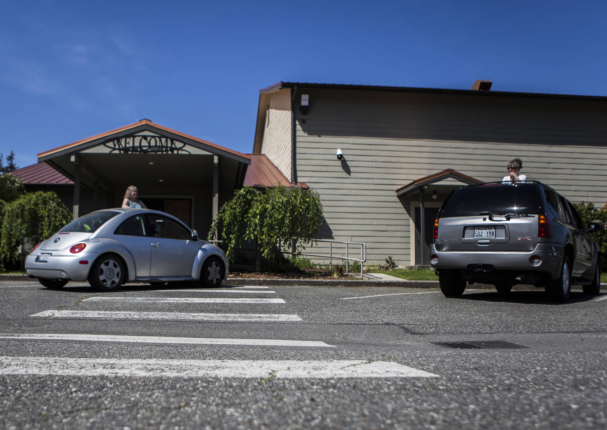 People chat from their cars before the start of the drive-in service at Marysville Foursquare Gospel Church on Sunday. (Olivia Vanni / The Herald)