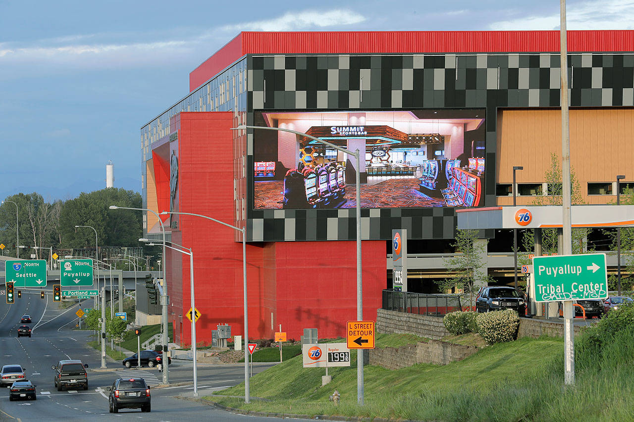 A large video display shows rows of slot machines inside the new Emerald Queen Casino in Tacoma. The casino is owned by the Puyallup Tribe of Indians and is currently closed. Hundreds of tribal casinos across the country have voluntarily closed because of the coronavirus pandemic, in many cases taking away a tribe’s primary source of revenue used to operate tribal government and social programs. (AP Photo/Ted S. Warren)