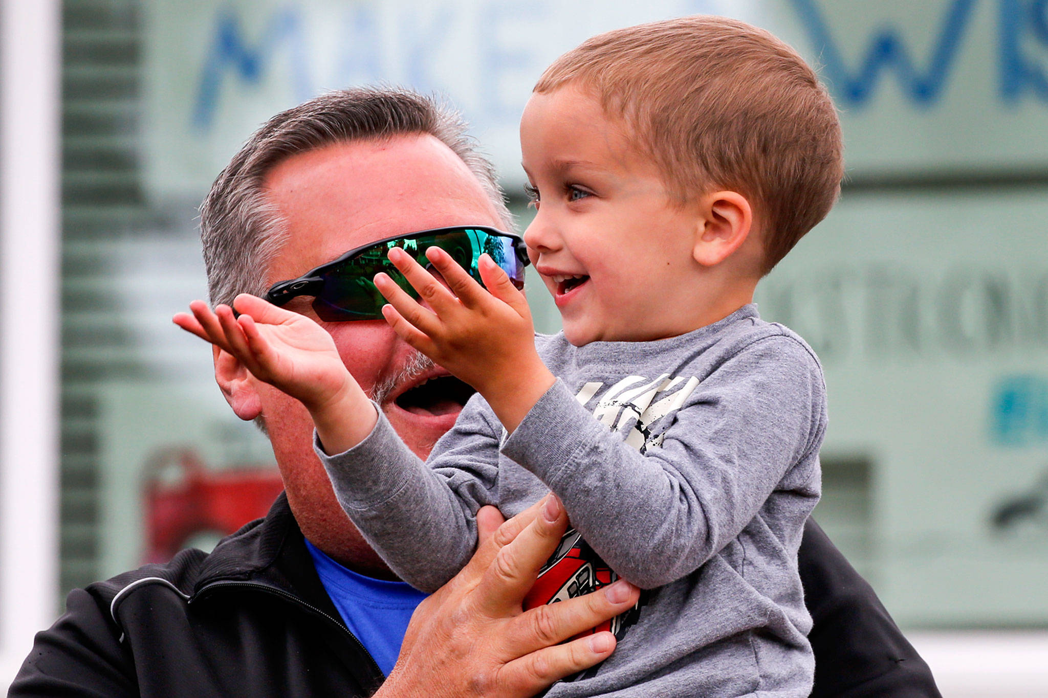 Kevin Terrell holds grandson Eli Kincaid, 3, for a special parade in front of his home Tuesday in Lynnwood. (Kevin Clark / The Herald)