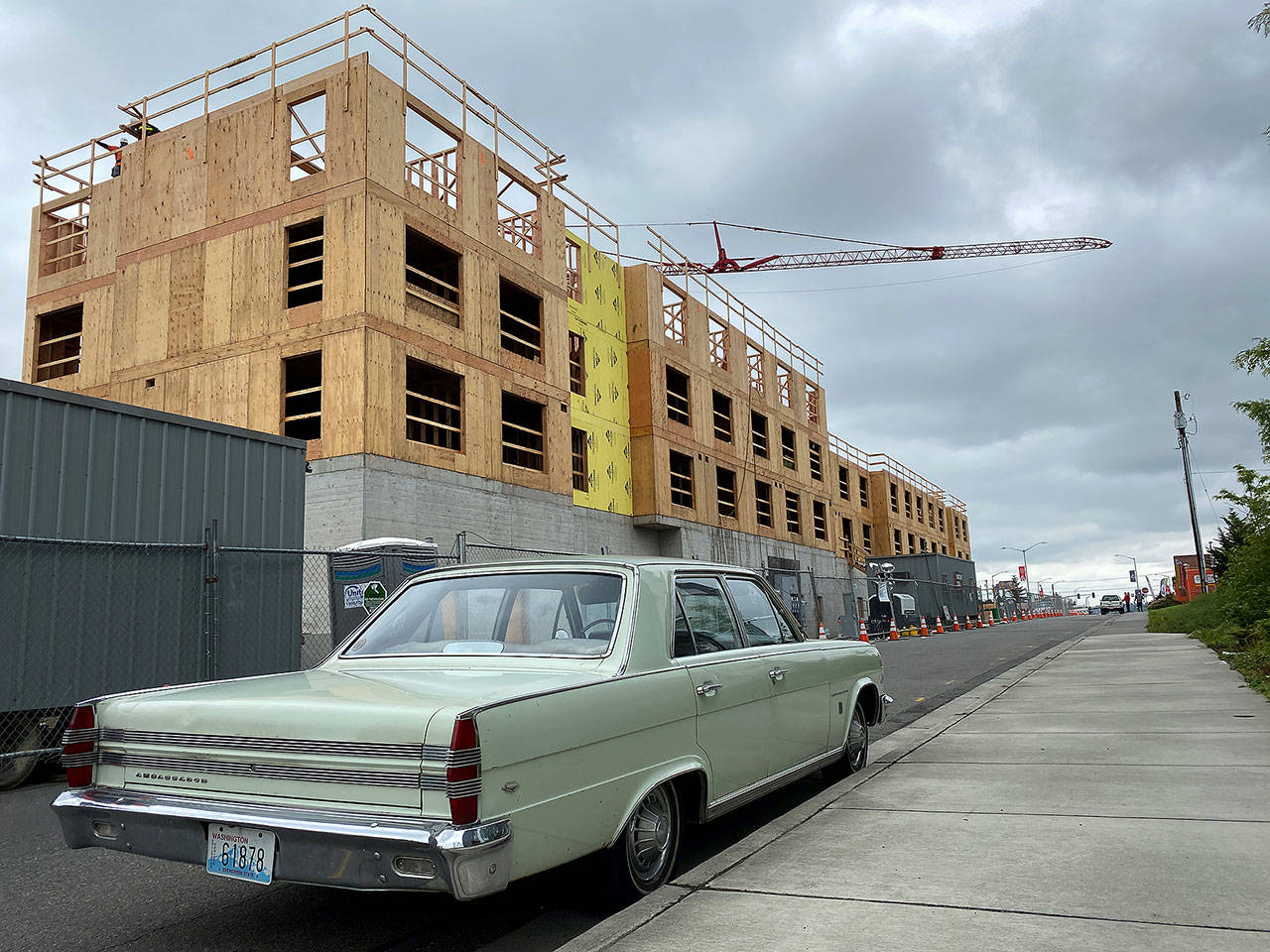 Gov. Jay Inslee has allowed the resumption of construction, and workers were busy Wednesday afternoon at this 5-story apartment project being built on North Broadway. (Sue Misao / The Herald)
