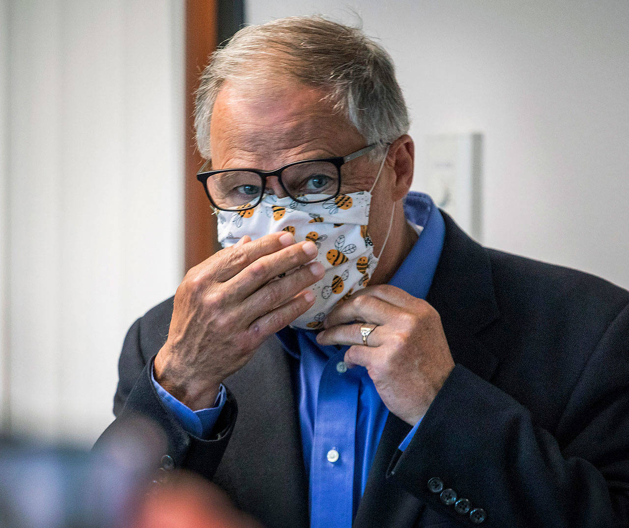 Washington Gov. Jay Inslee puts on his face mask after speaking to the media Wednesday, in Tumwater, about the state’s effort at contact tracing amid the coronavirus pandemic. (Steve Ringman/The Seattle Times via AP, Pool)