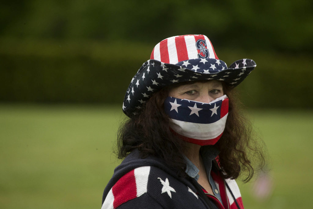 Denise Baker is decked out in red, white and blue as she visits Floral Hills cemetery. (Andy Bronson / The Herald)
