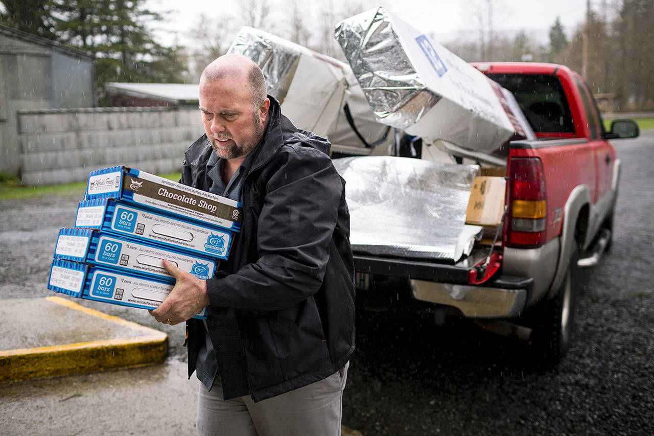 In this March 2014 photo, Gary Ray, then pastor of the Oso Community Chapel, carries chocolate bars as a donation for Oso landslide survivors to serve as “comfort food.” (Jordan Stead, seattlepi.com file)