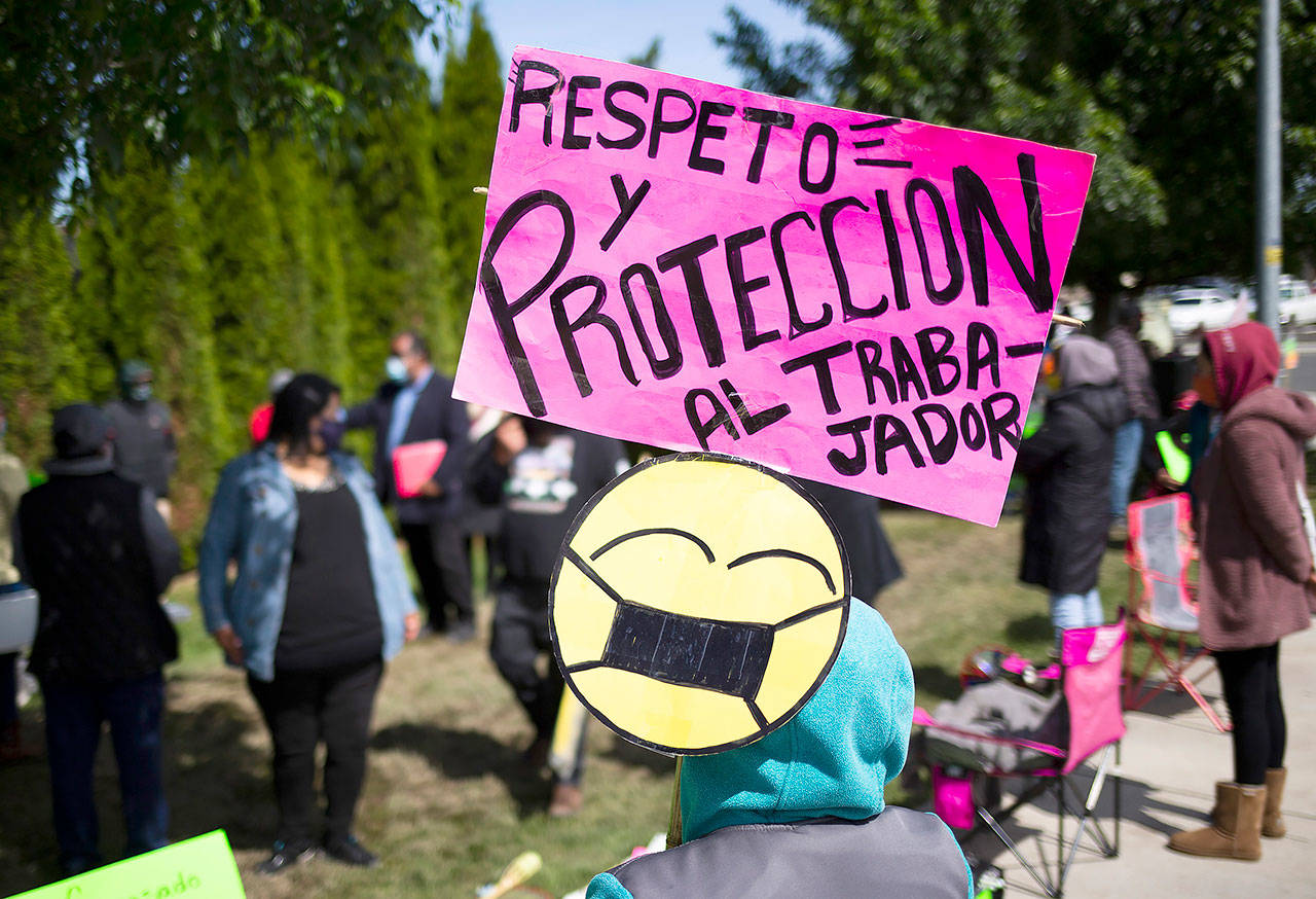 A striking worker holds a sign that says “respect and protection to the worker” in Spanish in front of Matson Fruit on Wednesday in Selah, Washington. (Evan Abell/Yakima Herald-Republic via AP)