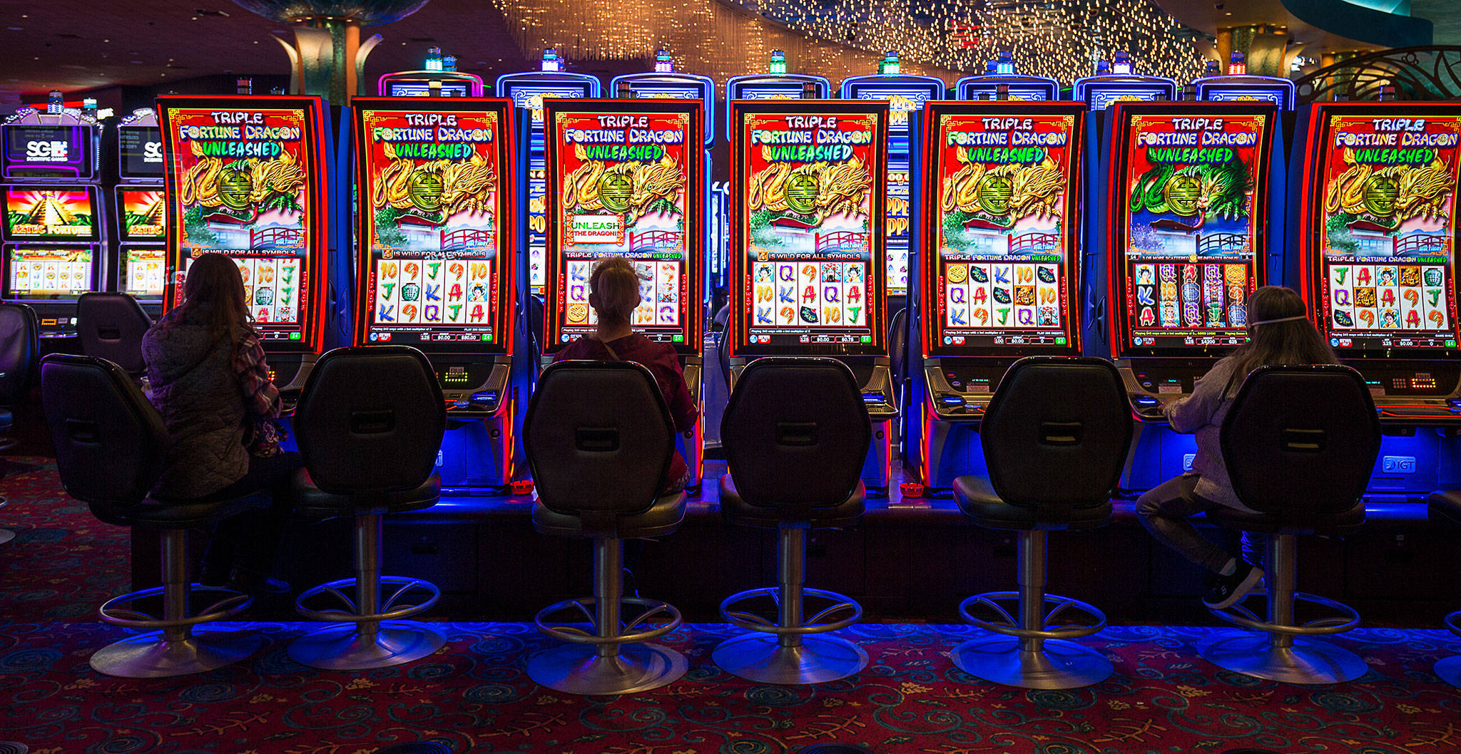 Slot machine players keep their distance Tuesday as the Tulalip Resort Casino reopens. (Andy Bronson / The Herald)