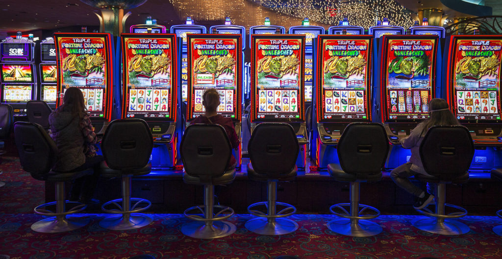 Slot machine players keep their distance Tuesday as the Tulalip Resort Casino reopens. (Andy Bronson / The Herald)
