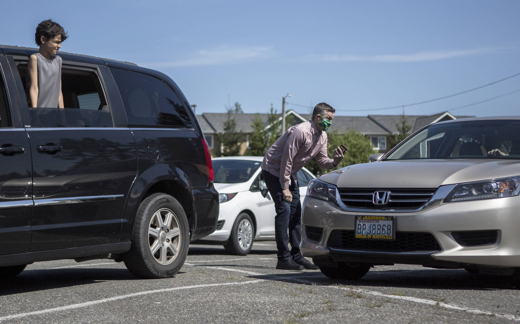 Pastor Aaron Thompson checks to make sure everyone can connect to a livestream of his service from the parking lot at Marysville Foursquare Gospel Church on May 10 in Marysville. (Olivia Vanni / The Herald)