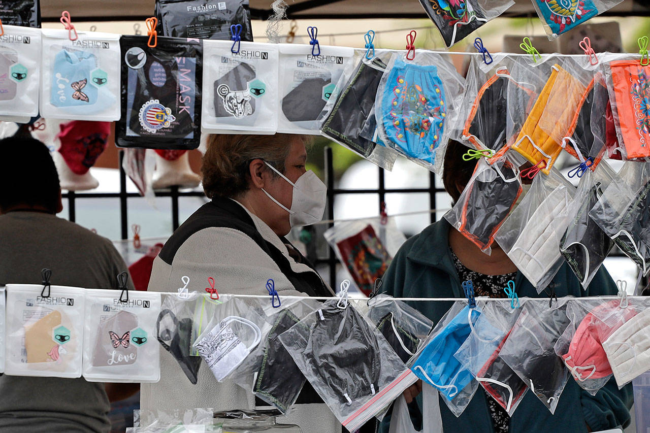 Shoppers browse a selection of face masks on a street in Chicago on May 22. Face masks have come to symbolize the tension between those who are taking precautions in the face of the coronavirus pandemic and those who don’t believe social distancing is necessary. (AP Photo/Nam Y. Huh)