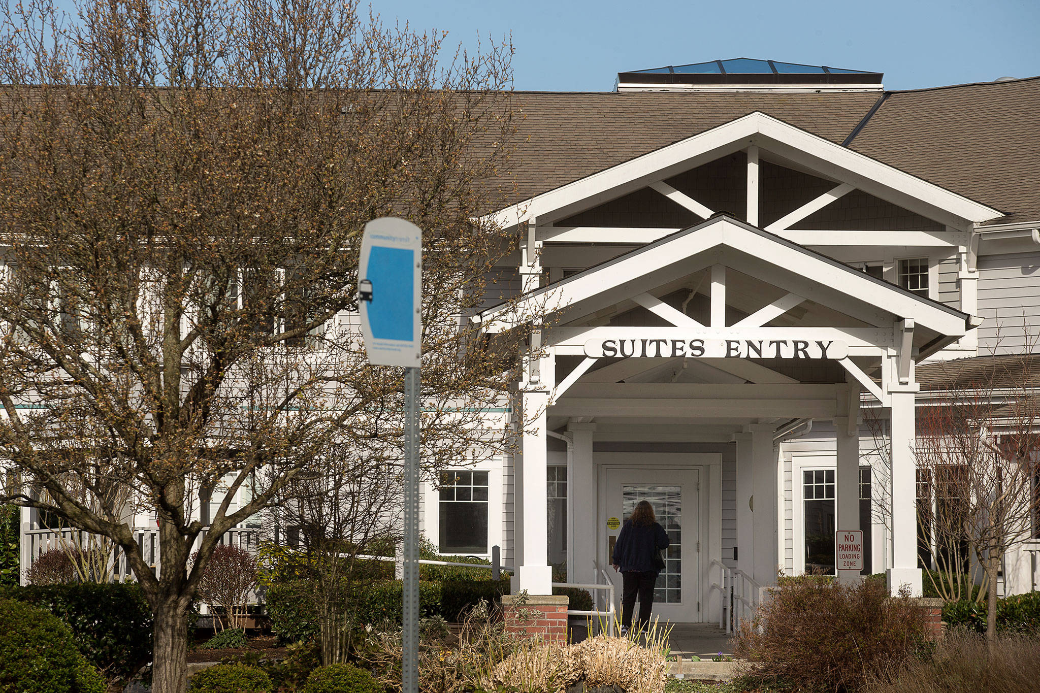 A woman walks up to closed doors at the Josephine Caring Community on March 11 in Stanwood. (Andy Bronson / Herald file)