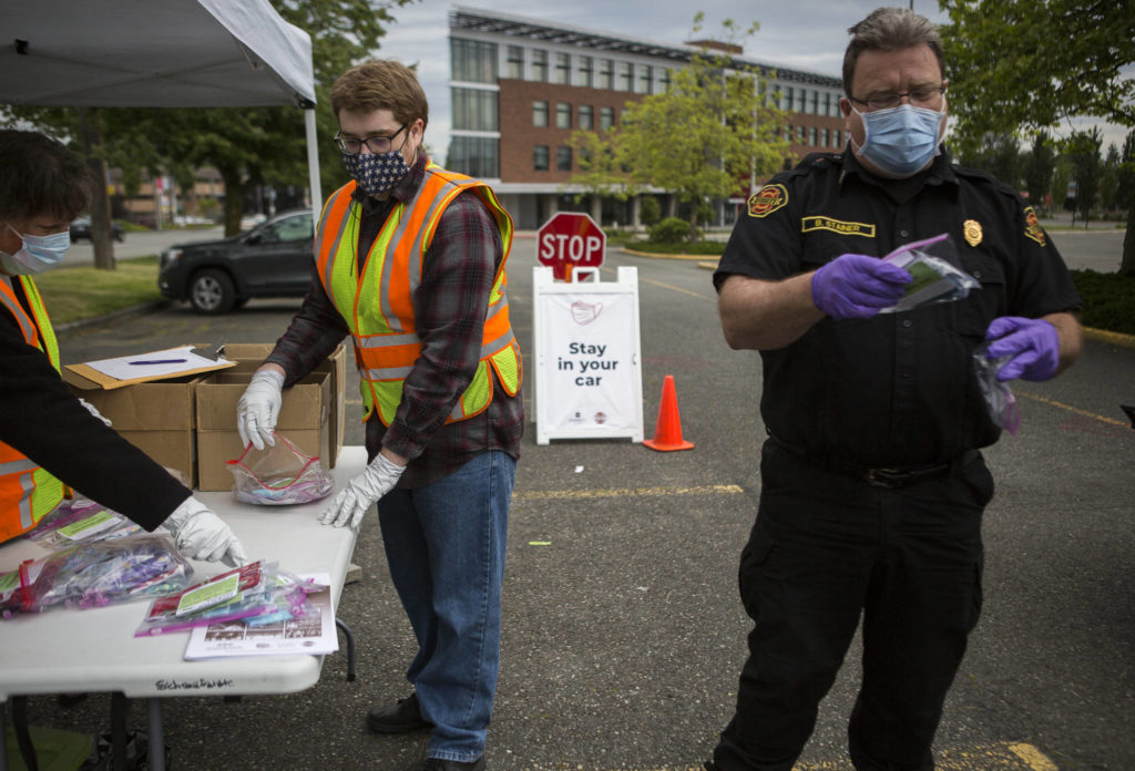 Volunteers sort and restock face masks at a recent free mask drive-thru hosted by Everett Emergency Management. (Olivia Vanni / The Herald)

