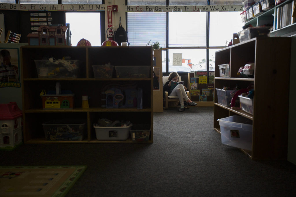 Indiana Smasne reads in an empty corner of a classroom. (Olivia Vanni / The Herald)
