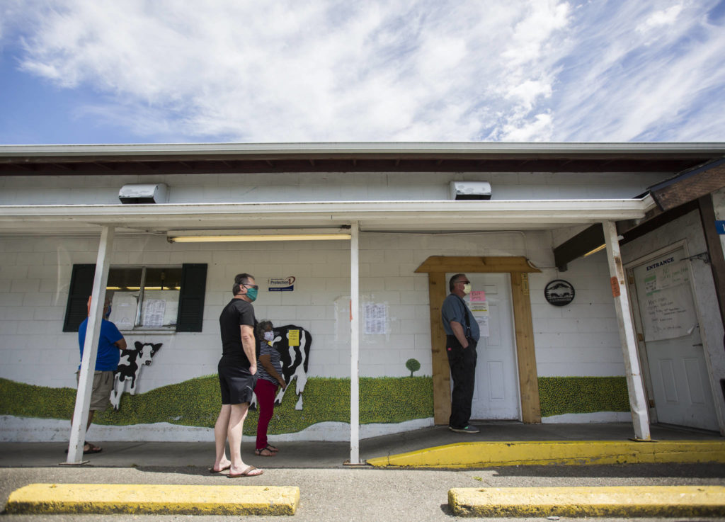 Customers form a line outside of Silvana Meats, which is limiting two customers inside at a time, on Friday, May 29, 2020 in Silvana, Wa. (Olivia Vanni / The Herald)
