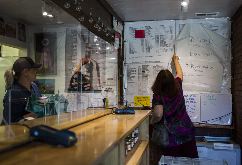 A customer reads through Silvana Meats extensive list of meats and cuts on Friday, May 29, 2020 in Silvana, Wa. (Olivia Vanni / The Herald)
