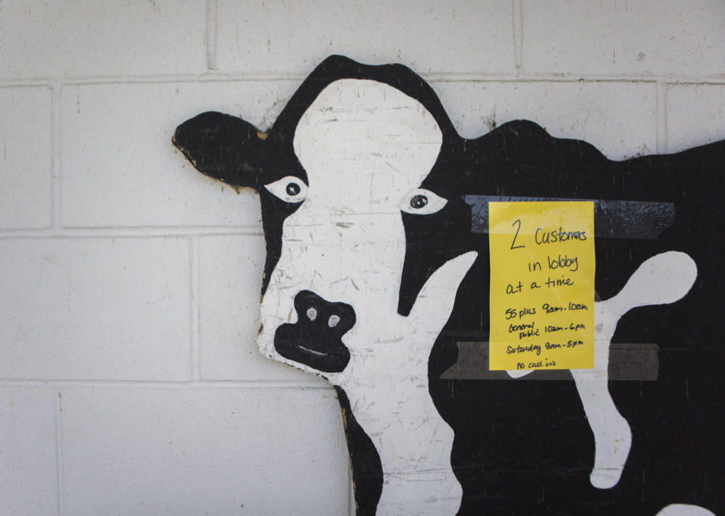 A sign alerting customers to a “2 customer in lobby” limit is taped to a cow cutout outside of Silvana Meats on Friday, May 29, 2020 in Silvana, Wa. (Olivia Vanni / The Herald)
