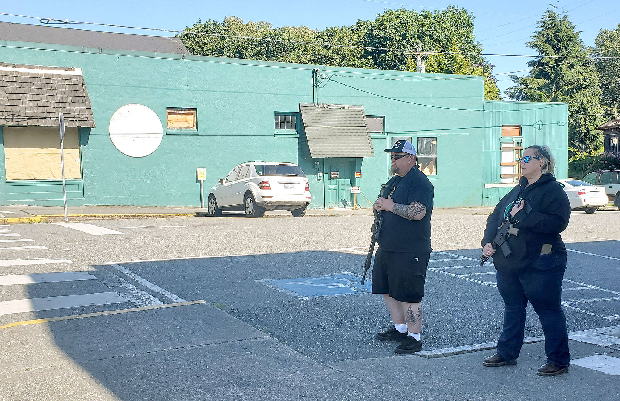 Armed citizens stand vigil in Snohomish on Monday. They declined to identify themselves. The man said they were there to “keep business owners and businesses safe. We don’t need our little town torn apart.” (Ian Davis-Leonard / The Herald)