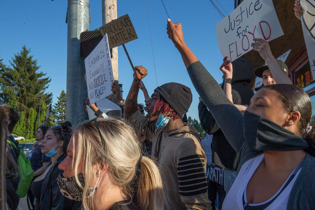 Protesters yell and hold signs at 2nd and D St in Snohomish on Monday in Snohomish. (Andy Bronson / The Herald)

