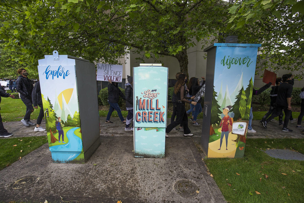 Protesters march past painted electrical boxes as they protest the killing of George Floyd on Tuesday, June 2, 2020 in Mill Creek, Wa. (Andy Bronson / The Herald)
