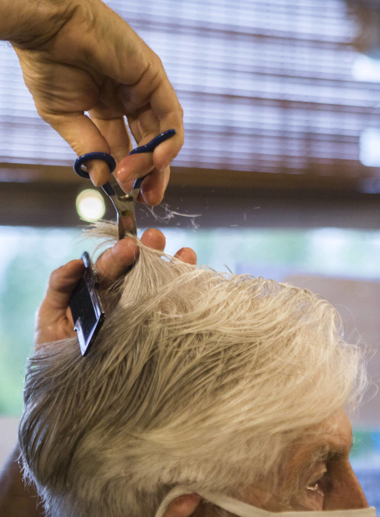 Steve Iblings begins trimming Bob DeFrang’s hair Saturday in Lake Stevens. (Olivia Vanni / The Herald)
