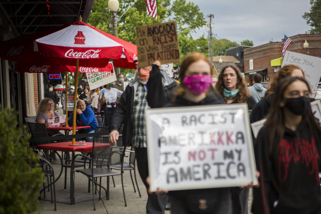 Protesters walk by Cathouse Pizza on First Street on Friday in Snohomish. (Olivia Vanni / The Herald)
