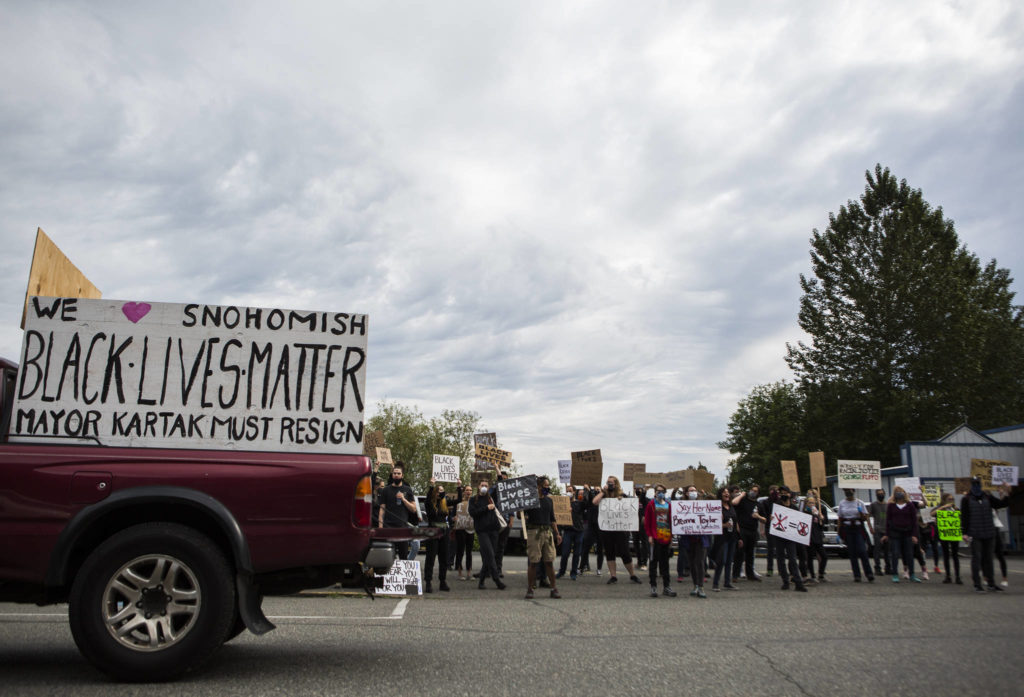 Protesters gather along First Street on Friday in Snohomish. (Olivia Vanni / The Herald)
