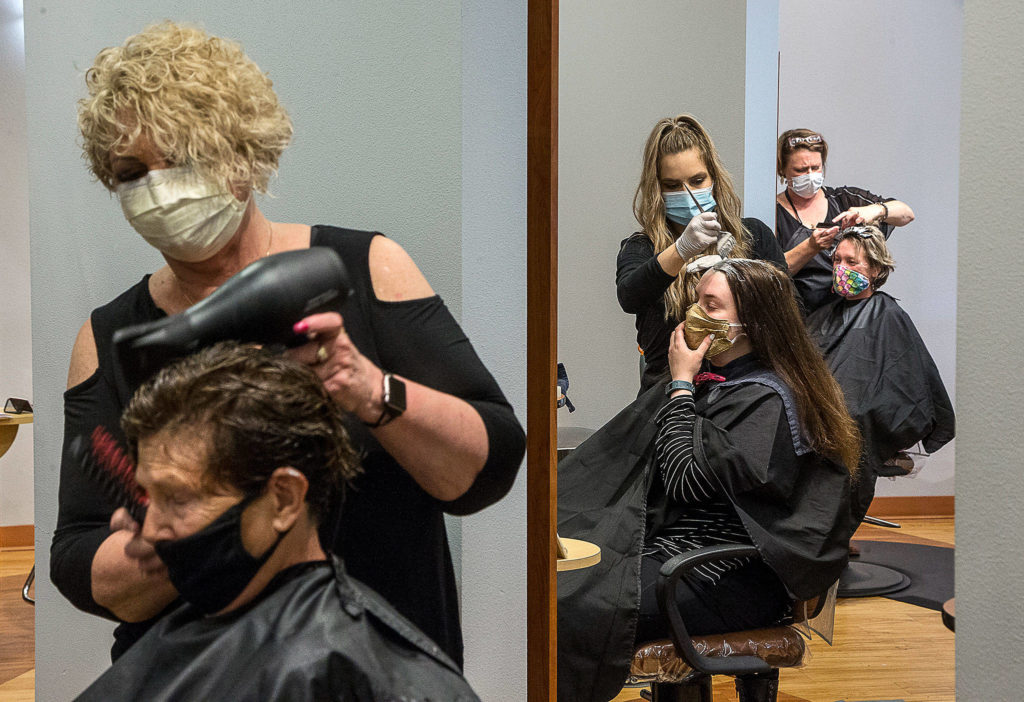 Stylists at Salon Zuberenz in Lynnwood have their chairs and hands full as clients come in for haircuts and styling, after months away due to the COVID-19 shutdown. (Andy Bronson / The Herald)
