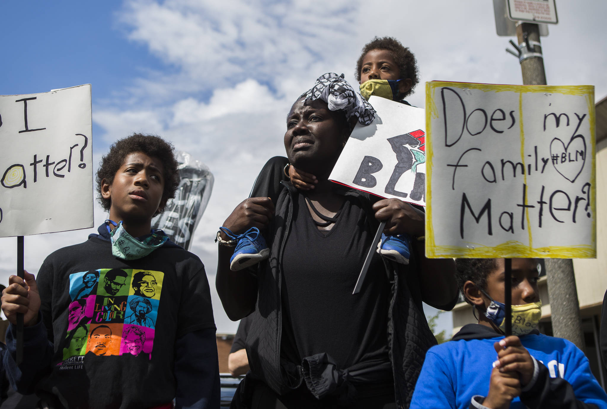 Adja Maïmouna Fame (center) becomes emotional as she stands with her three sons, Djibril Garcia (left), Kamil Garcia (top) and Kareem Garcia during the Black Lives Matter protest on Saturday in Everett. (Olivia Vanni / The Herald)