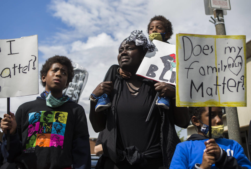 Adja Maïmouna Fame (center) becomes emotional as she stands with her three sons, Djibril Garcia (left), Kamil Garcia (top) and Kareem Garcia during the Black Lives Matter protest on Saturday in Everett. (Olivia Vanni / The Herald)
