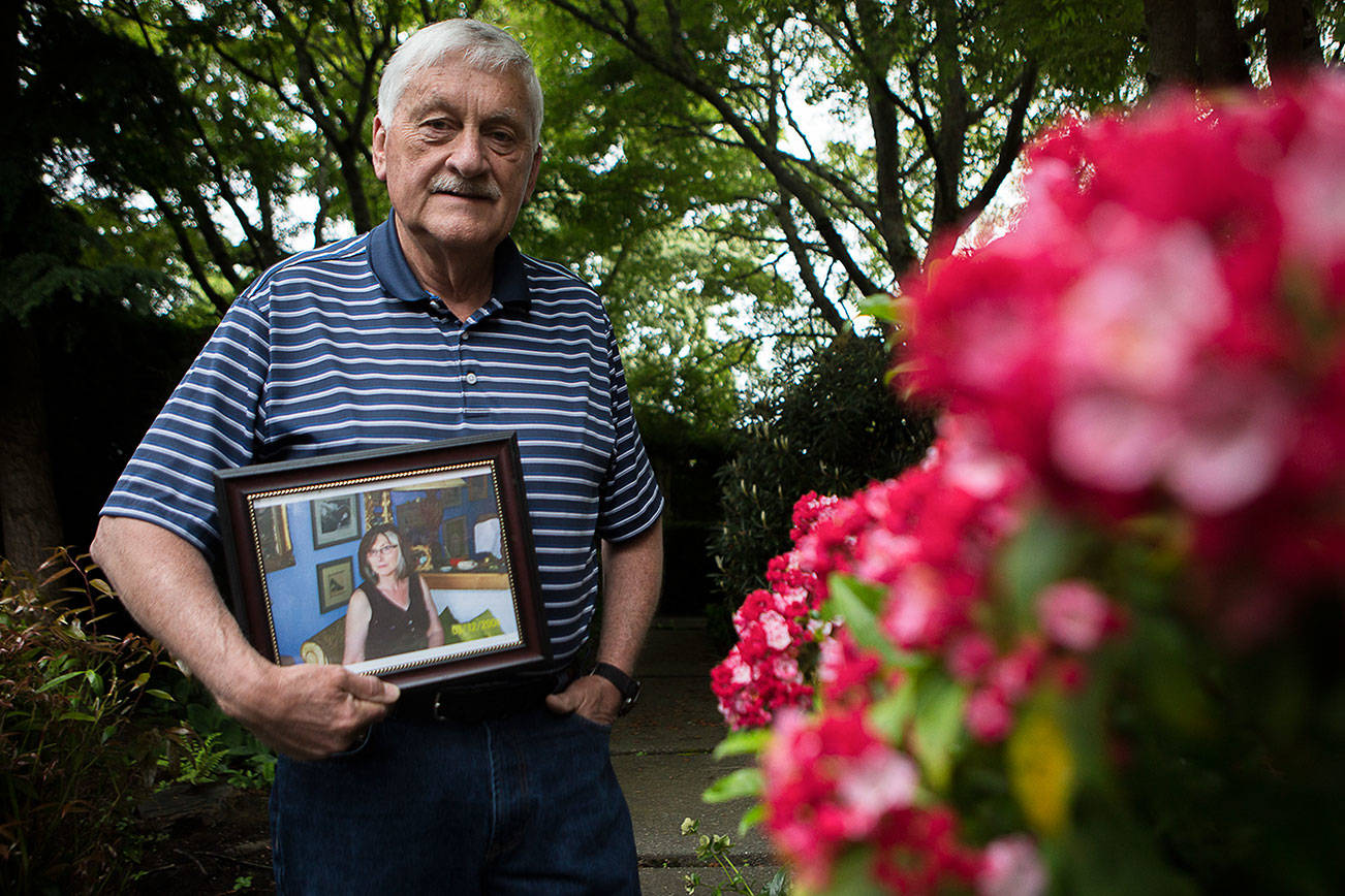 Larry Jubie holds a photograph of his sister Christine Jubie outside his home on Friday, June 12, 2020 in Everett, Wa. Christine Jubie, who lived at a care facility in Everett, died of COVID-19 on June 2. She was 67. (Olivia Vanni / The Herald)