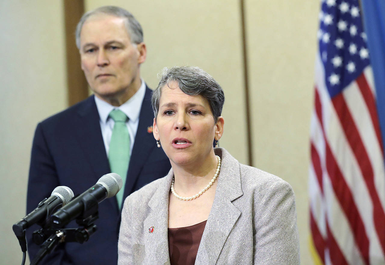 Washington Gov. Jay Inslee looks on as Suzi LeVine (right), the state’s Employment Security Department commissioner, talks to reporters in 2019. (AP Photo/Ted S. Warren)