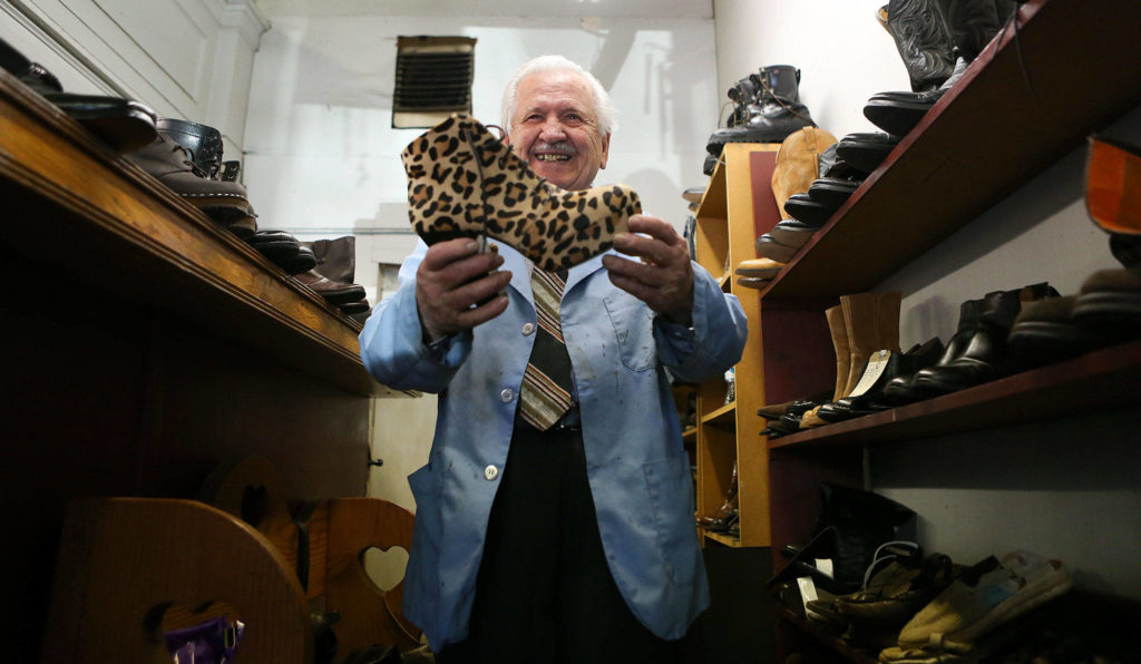 Mike Papadimitriou, owner People’s Shoe Repair, holds up a leopard print high held shoe left behind by a customer in this photo taken in 2017. (Andy Bronson / The Herald)
