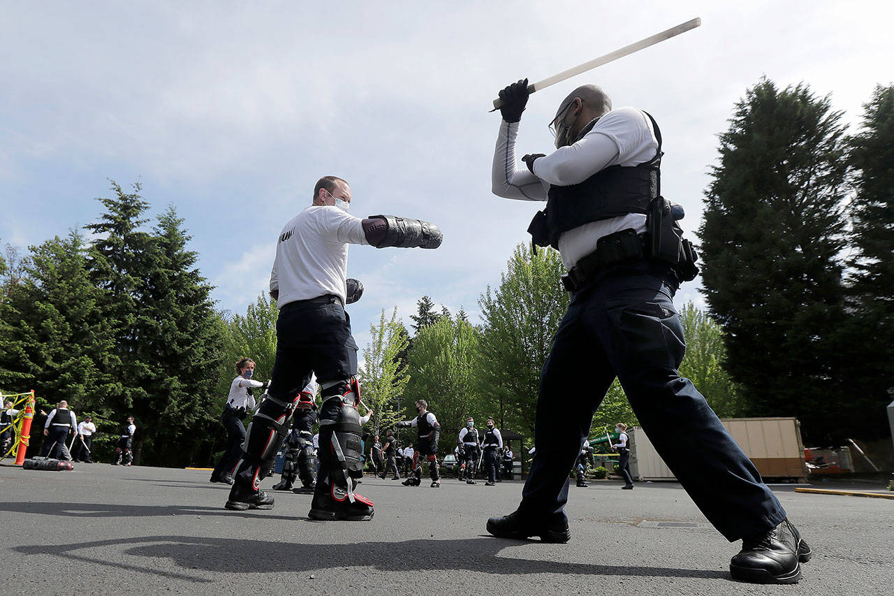 In this June 4 photo, law enforcement officers at the Washington state Criminal Justice Training Commission training facility in Burien take part in a class on the use of batons as part of the more than 700 hours of training police and other officers are required to to through in the state of Washington. (AP Photo/Ted S. Warren)