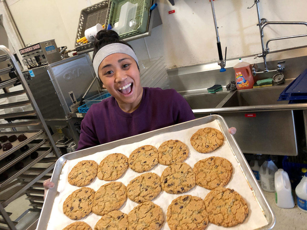 Aimee Policarpio takes cookies out of the oven at the Midnight Cookie in Everett. (Midnight Cookie)
