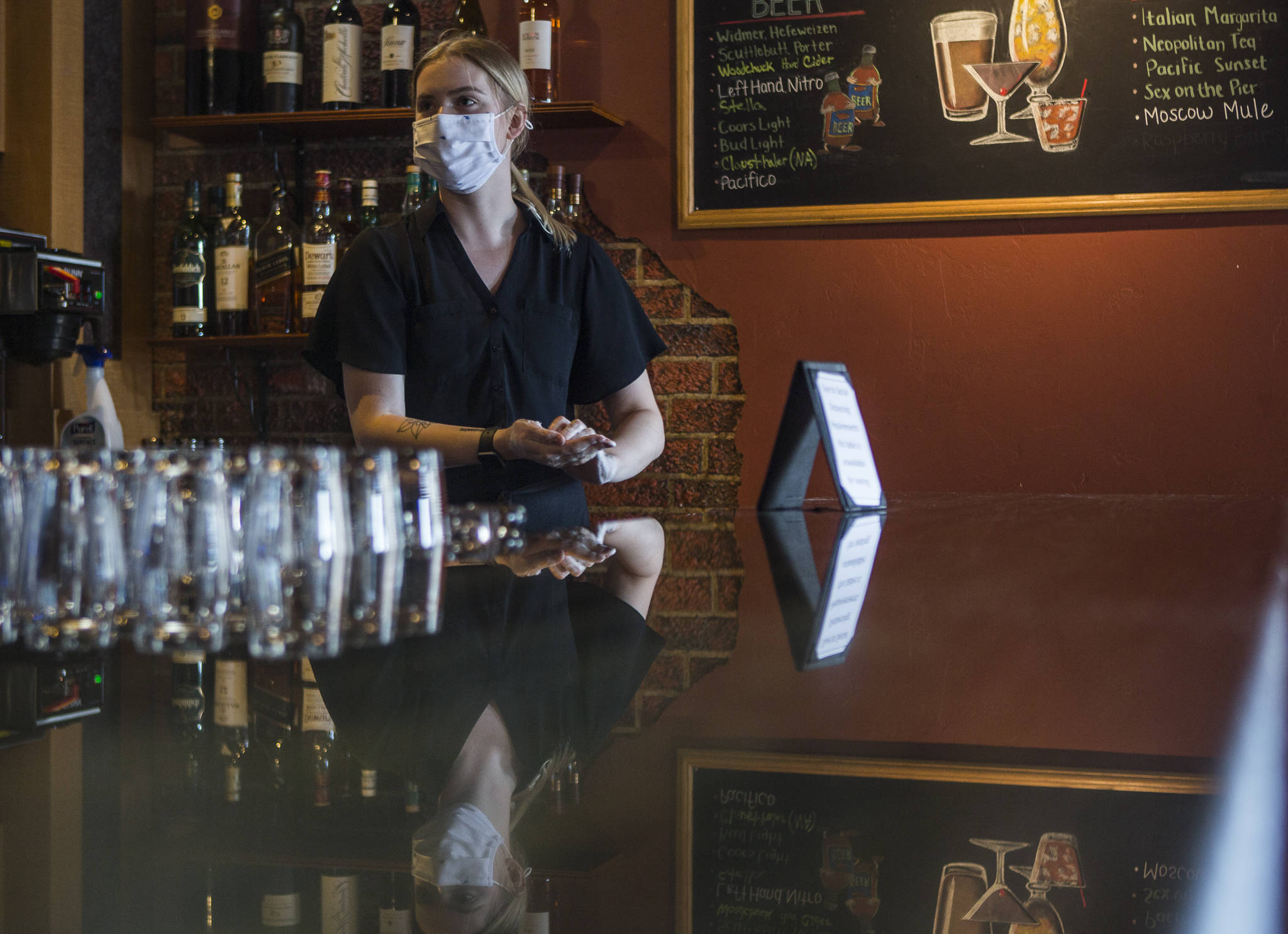 Kayla Salatino washes her hands between waiting on customers at Lombardi’s Italian Restaurant on Saturday in Everett. (Olivia Vanni / The Herald)