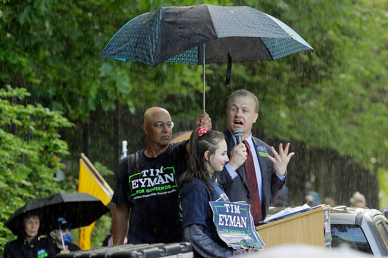 Tim Eyman (right), a Republican candidate for Washington governor, speaks May 14 during a protest rally at the Capitol in Olympia. (Ted S. Warren / Associated Press)