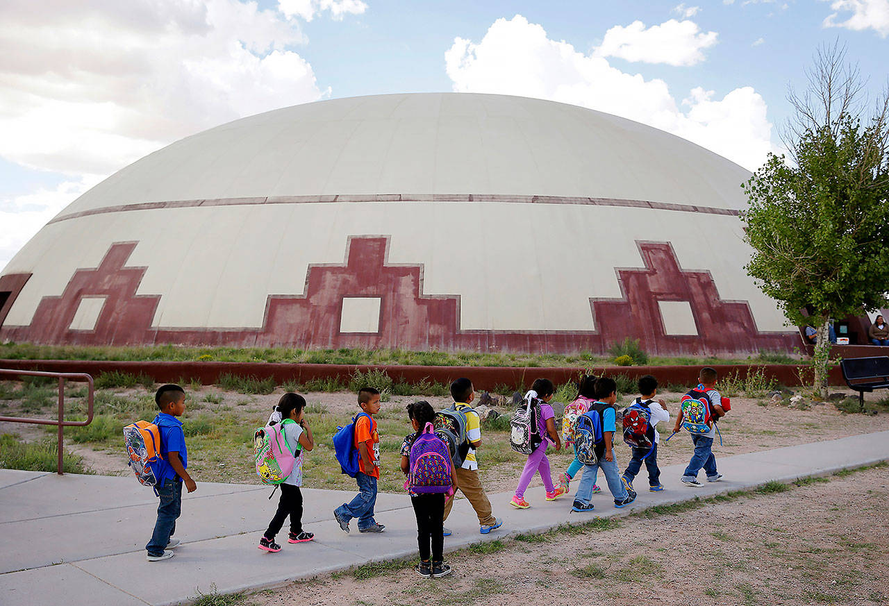 In this 2014 photo, students walk between buildings at the Little Singer Community School in Birdsprings, Arizona, on the Navajo Nation. The tribe is among plaintiffs in a federal lawsuit that sought to keep the U.S. Treasury Department from disbursing coronavirus relief funding for tribes to Alaska Native corporations. (AP Photo/John Locher, File)