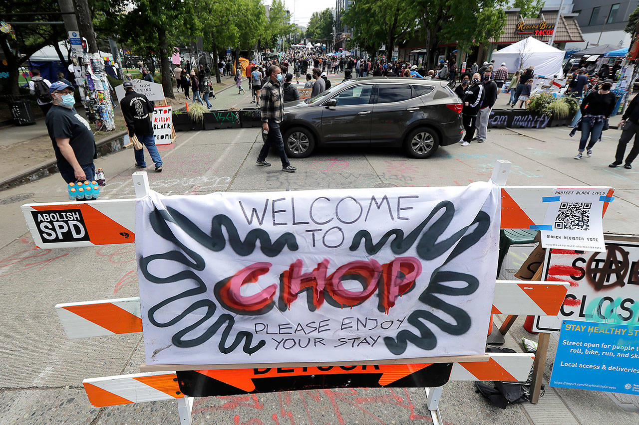 A sign reads “Welcome to CHOP,” on Sunday inside what has been named the Capitol Hill Occupied Protest zone in Seattle. The name is a change from CHAZ (Capitol Hill Autonomous Zone) that was used earlier in the week. (AP Photo/Ted S. Warren)
