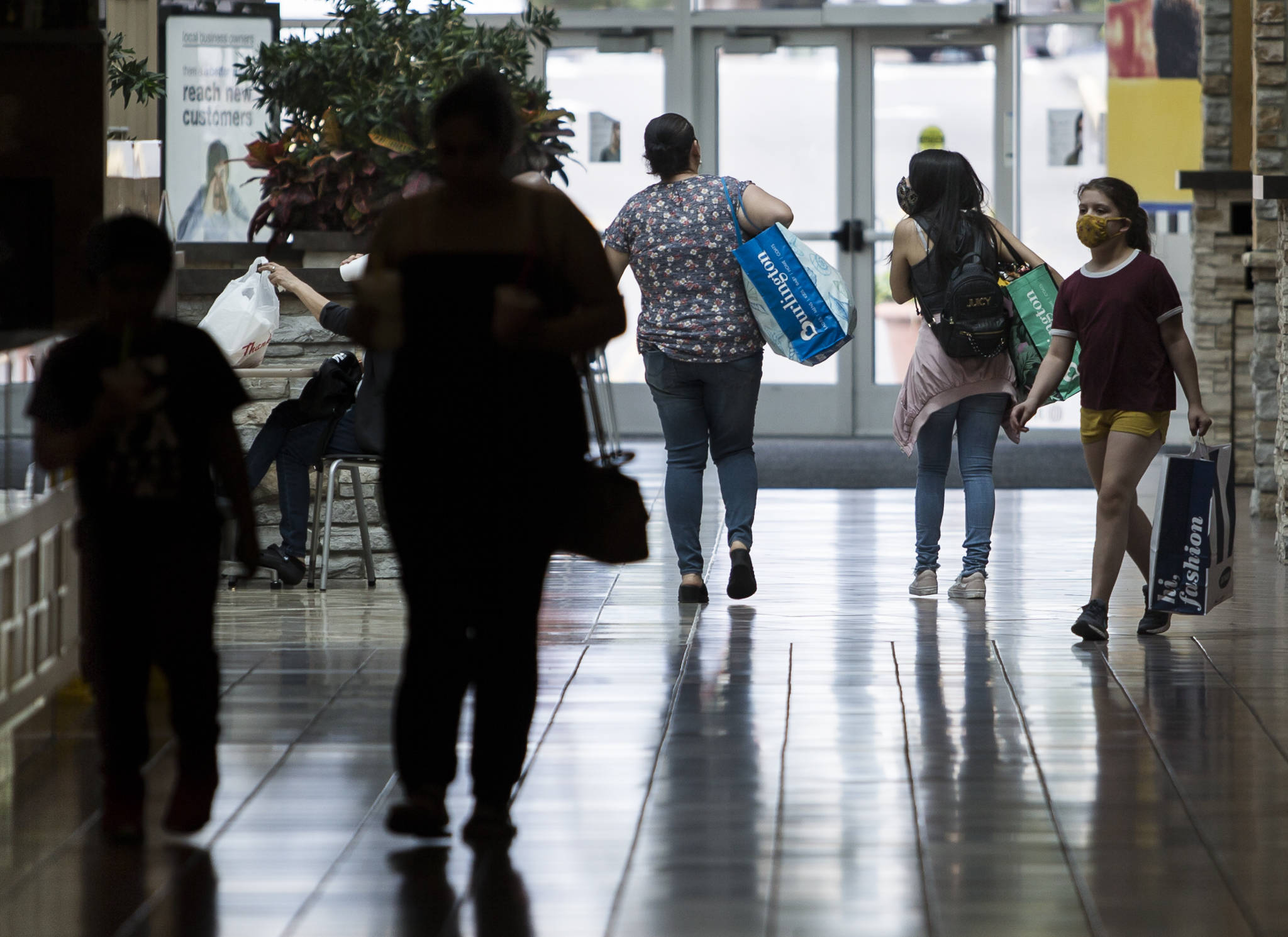 People walk through Everett Mall wearing masks while shopping on Friday. (Olivia Vanni / The Herald)