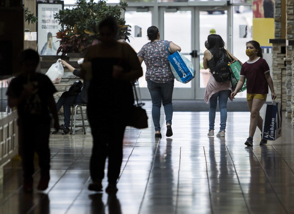 People walk through Everett Mall wearing masks while shopping on Friday. (Olivia Vanni / The Herald)
