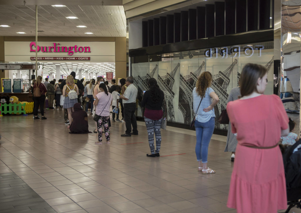 People wait in line at the Burlington store at Everett Mall on Friday. It was the first day the store was open since temporarily closing due to the coronavirus outbreak. (Olivia Vanni / The Herald)
