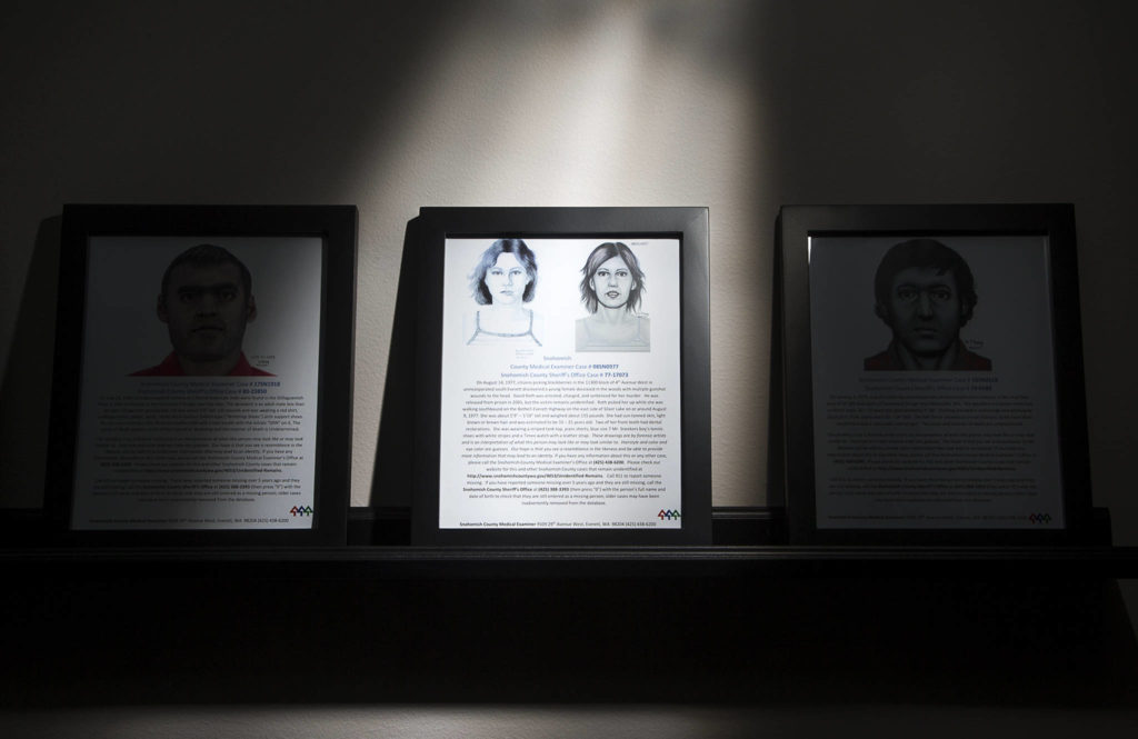 On a shelf at the Snohomish County Medical Examiner’s Office, an artist drawing of a Jane Doe sits among posters of missing persons. (Andy Bronson / The Herald)
