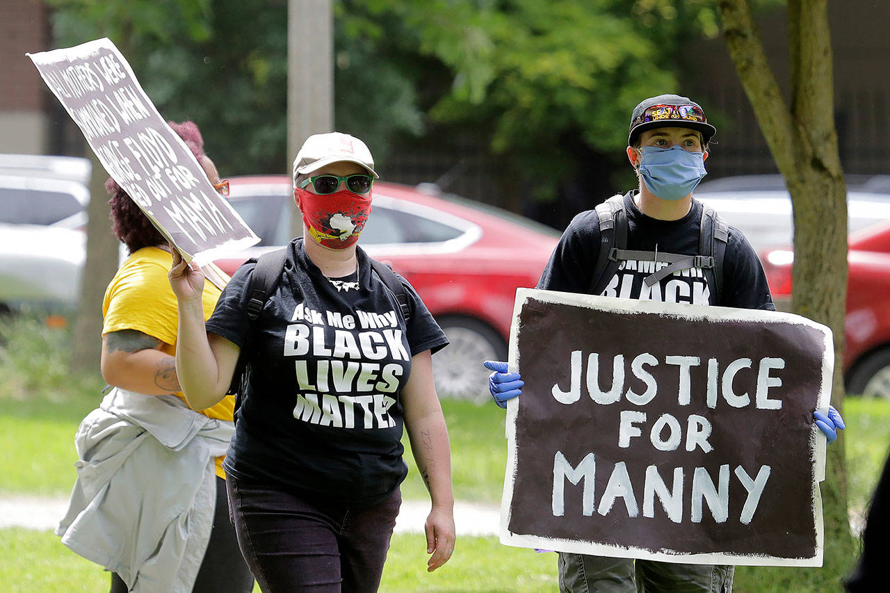 A protester holds a sign that reads “Justice for Manny” on June 5 in Tacoma during a protest against police brutality and the death of George Floyd, a black man who died after being restrained by Minneapolis police officers on May 25. (AP Photo/Ted S. Warren)