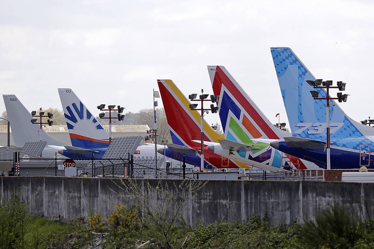 A line of Boeing 737 Max jets sit parked on the airfield adjacent to a Boeing production plant on April 20 in Renton. (AP Photo/Elaine Thompson)
