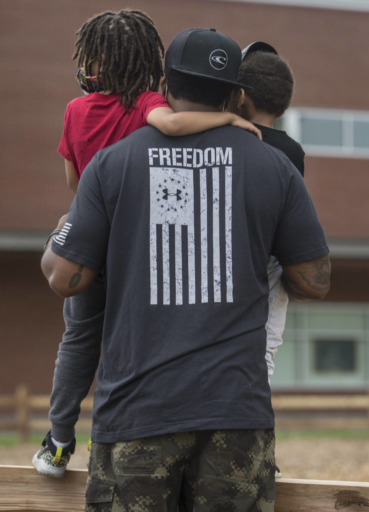 Torry Hollimon holds his sons, Trace Hollimon, 5, and Tristen Hollimon, 3, while they listen to speakers during a Juneteenth protest on Friday, June 19, 2020 in Snohomish, Wa. (Olivia Vanni / The Herald)
