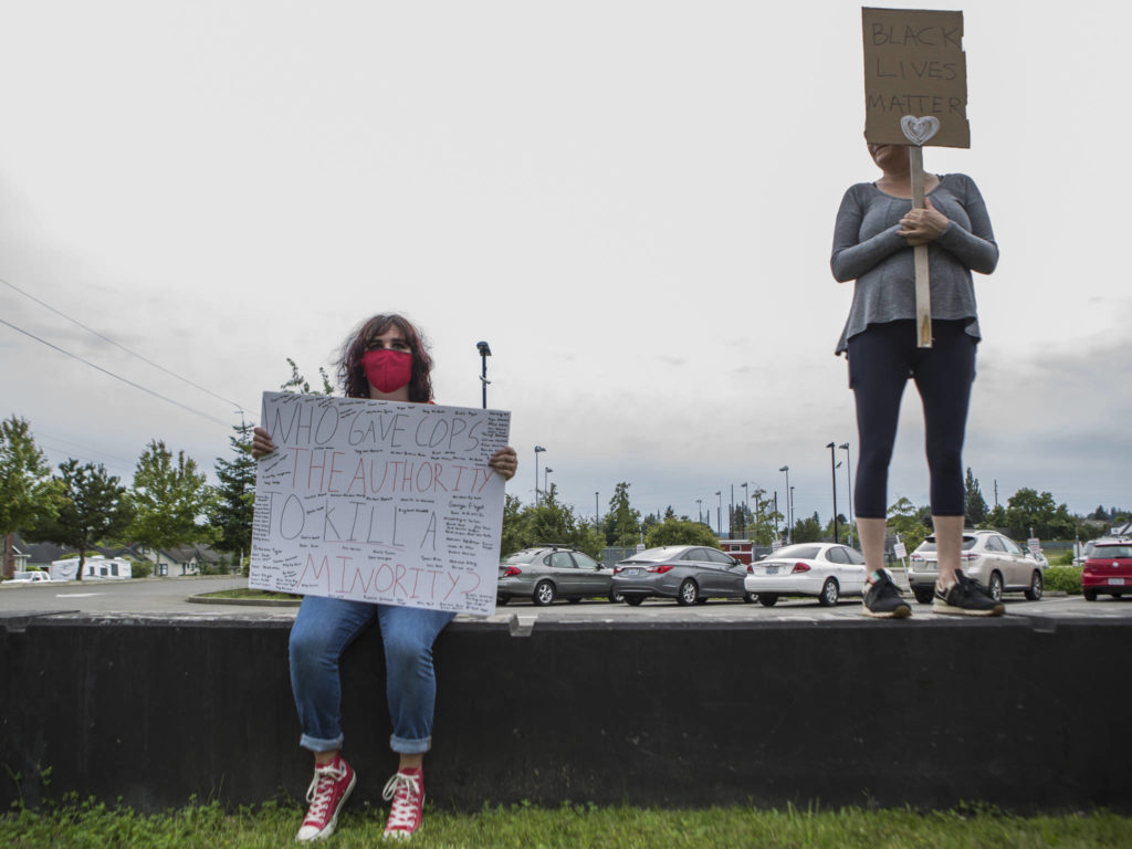 AhLana Ames sits while protesters fill in the space as they wait for speakers to start on Friday, June 19, 2020 in Snohomish, Wa. (Olivia Vanni / The Herald)
