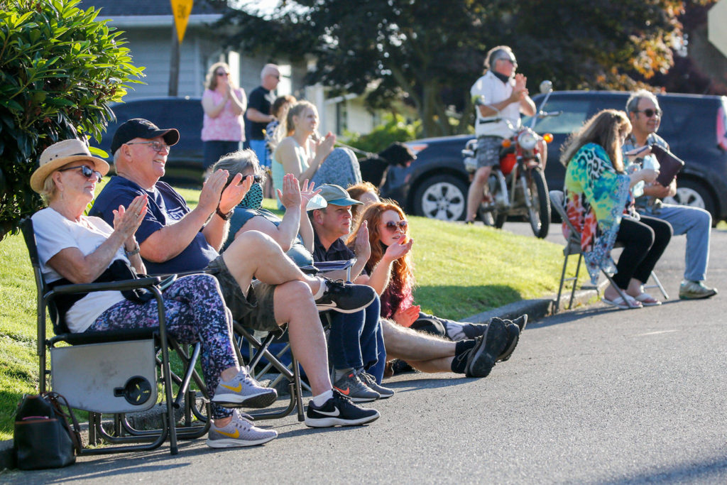 Kay and Dean Olsen (at left) join other neighbors as they listen to bands playing from Jake Bergevin’s deck Thursday evening in Everett on June 25, 2020. (Kevin Clark / The Herald)
