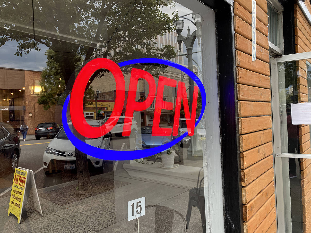 A restaurant on Colby Avenue in Everett displays its lit-up “Open” sign. (Sue Misao / The Herald)