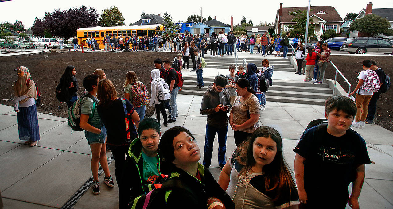 As buses drop them off Sept. 4, North Middle School students arrive outside the then-newly renovated school in Everett. The Everett School District is determining how instruction will be delivered this fall, starting with community input this week. (Dan Bates / Herald file)