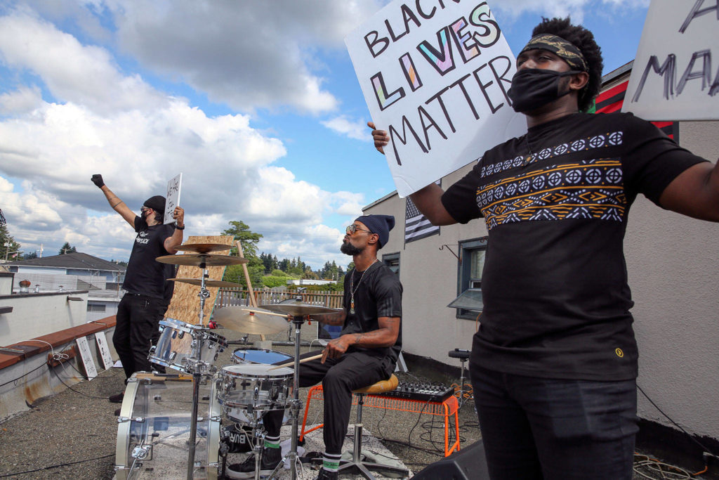 Jordon Jeffries (left), Chris Anderson (center) and Xavier Bennett rally on a rooftop for Black Lives Matter on July 4 in Marysville. (Kevin Clark / The Herald)
