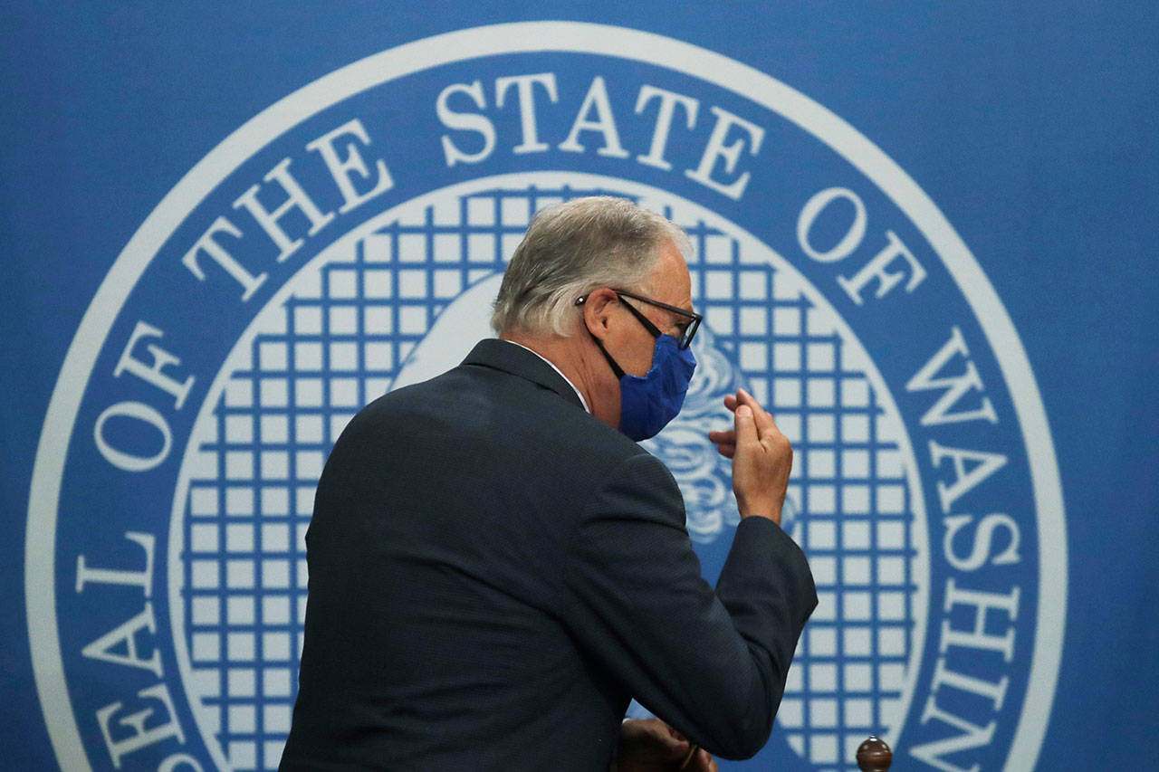 Washington Gov. Jay Inslee signs “thank you” to one of his sign language interpreters as he wears a face mask after finishing a news conference June 23 at the Capitol in Olympia. (AP Photo/Ted S. Warren file)