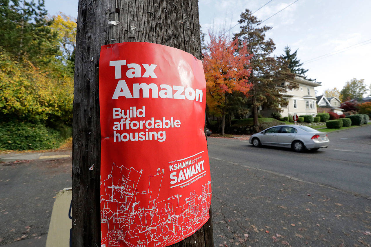 A campaign poster for Seattle City Council incumbent candidate Kshama Sawant is posted outside her campaign headquarters in Seattle in Oct. 2019. The City Council on Monday approved a new tax on big businesses two years after the council repealed a similar tax amid pressure from corporations such as Amazon. (AP Photo/Elaine Thompson, File)